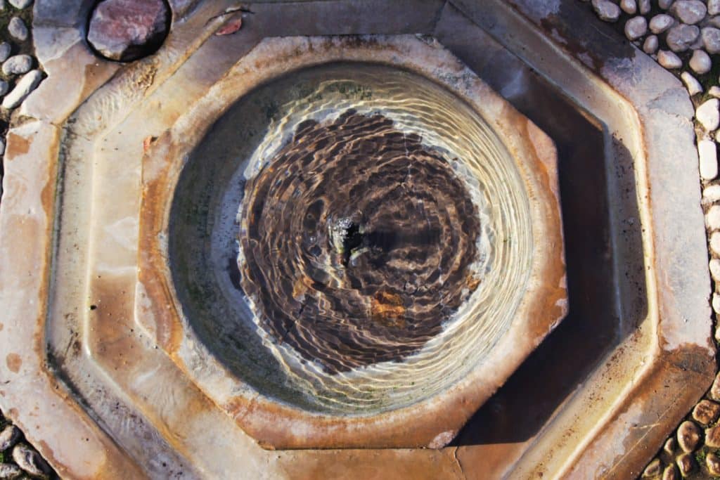 Iron stains and mineral deposit in rusted water fountain.